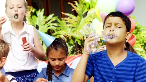 Happy-friends-playing-with-bubble-wand-in-backyard-4k