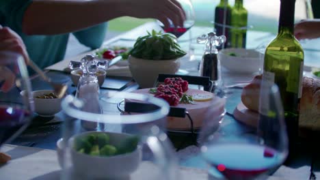 La-gente-bebiendo,-comiendo-y-hablando-de-detalles.-Cuatro-amigos-caucásica-hombre-y-una-mujer-mediterránea-ensalada-italiana,-carne-de-ternera-y-pan-almuerzo-o-cena.-Fiesta-de-verano-en-casa-de-videojuegos-moderna-casa-4k