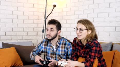 Guy-and-girl-sit-on-couch-and-play-console-game,-guy-win-50-fps