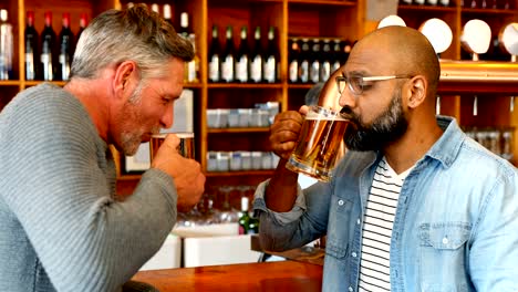 Amigos-tostado-vaso-de-cerveza-en-el-mostrador-en-el-restaurante-4k