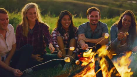 Freunden-entspannen-bei-Sonnenuntergang-am-Lagerfeuer