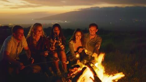 Freunden-entspannen-bei-Sonnenuntergang-am-Lagerfeuer