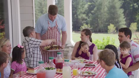 Gruppe-von-Personen-essen-und-genießen-Sie-einen-Hinterhof-Grill