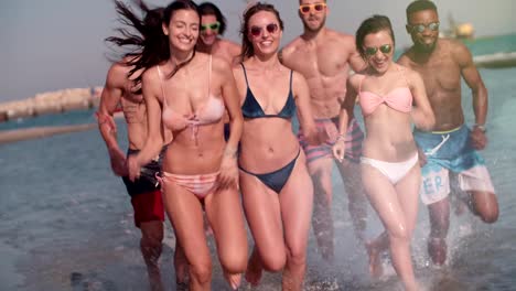 Young-multi-ethnic-friends-on-summer-holidays-running-on-the-beach