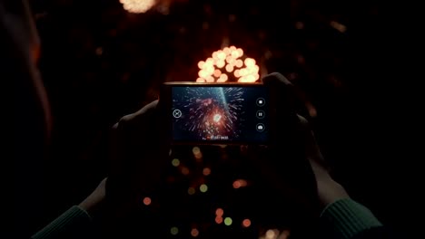 Silhouette-of-a-man-photographing-fireworks-at-night-sky.-Beautiful-salute-in-honor-of-the-holiday