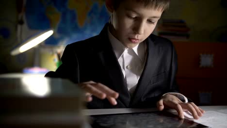 Junge,-die-Hausaufgaben-zu-Hause-mittels-tablet