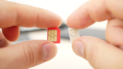 Hand-hält-einen-roten-micro-SIM-und-weißen-Nano-SIM-Karten