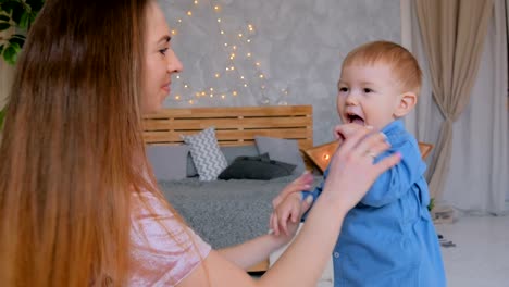 Happy-young-mother-and-her-baby-son-playing-togerher