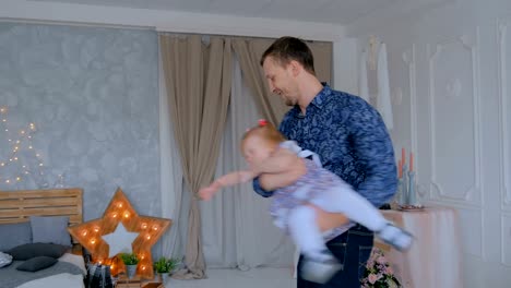 Young-father-spinning-his-happy-daughter