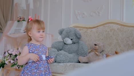 Portrait-of-funny-little-girl-with-bear-doll-at-home