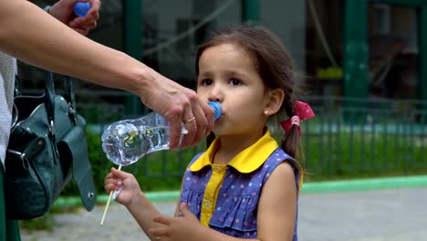 Ein-kleines-Mädchen-trinkt-aus-einer-Plastikflasche.