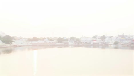 Husband-and-wife-talking-against-the-beautiful-sunset-at-Pushkar-Lake,-India,-handheld