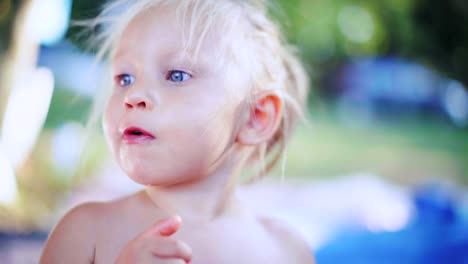 Nahaufnahme-von-einem-hungrigen-kleinen-Mädchen-mit-blonden-Haaren-Essen-Trauben-im-Sommerpark.-Konzept-der-gesunde-Babynahrung