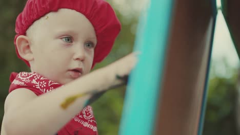 Close-up-portrait-little-painter-at-work-with-palette