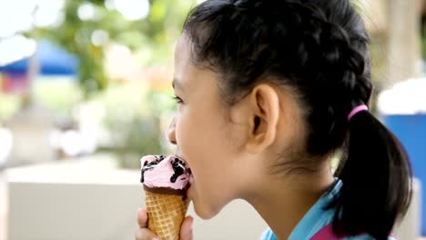 Slow-motion-Asian-little-girl-is-eating-ice-cream-with-happiness