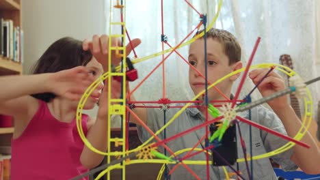 Jungen-und-Mädchen-bauen-einen-Turm-aus-Spielzeug-zu-Hause