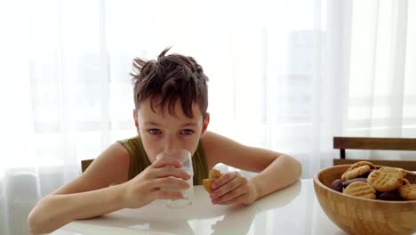 Junge-Essen-hausgemachte-Kekse-mit-Milch-in-der-Küche-zu-Hause.