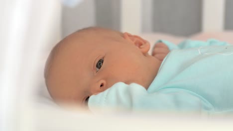 Neugeborenes-Baby-ruhig-im-Bett-liegen