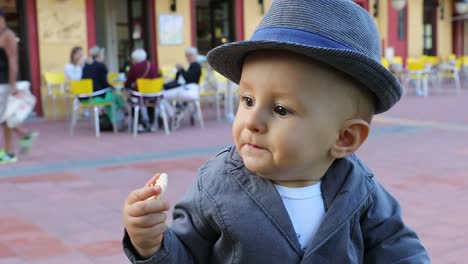 Niño-lindo-con-su-sombrero-italiano-comiendo-un-pastel-de-arroz