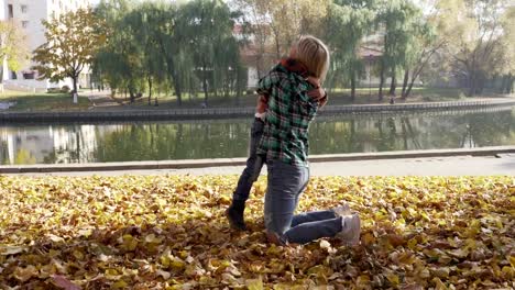 Junge-Mutter,-die-Spaß-mit-ihrem-Sohn-im-Herbst-Park-am-sonnigen-Tag