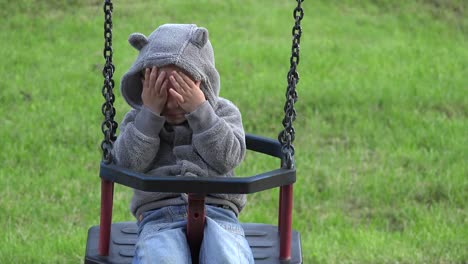 Niño-divertido-juego-ocultar-y-buscar,-el-equilibrio-en-una-silla-de-columpio-de-niño-sonriente