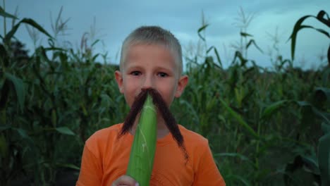 Un-muchacho-con-bigote-de-seda-del-maíz.-Boy-hacer-un-bigote-de-pelo-de-maíz