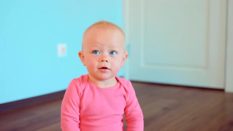 Close-up-portrait-of-a-smiling-cute-little-girl-sitting-on-the-floor-of-a-house-in-a-room