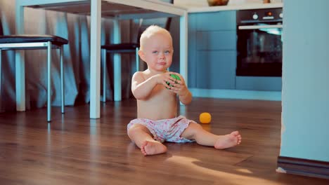 Töchterchen-am-Boden-sitzen-und-spielen-mit-Spielzeug