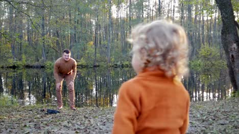 Glücklich-kleiner-Junge-läuft-am-See-im-Herbst-Park