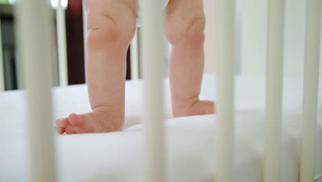 Niedliche-Baby-spielt-in-ihrer-Krippe-zu-Hause