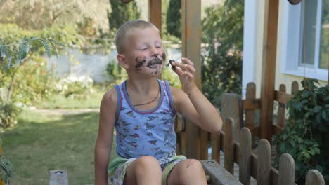 Niño-come-helado.-muchacho-untó-su-cara-con-la-comida.-Niño-comer-helado-de-un-cono-de-galleta-negra.