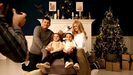 Christmas-photo-session-in-the-studio-family-father-mother-and-two-daughters-being-photographed-by-photographer