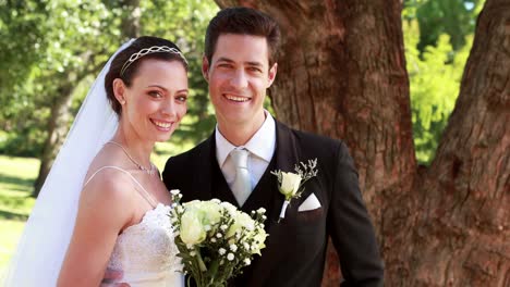 Feliz-pareja-de-recién-casados-sonriendo-a-la-cámara