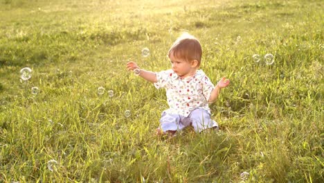 Baby-sitzt-auf-dem-Rasen.