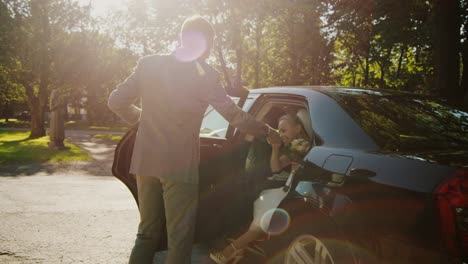 Novio-ayuda-a-novia-a-salir-el-coche-de-boda.