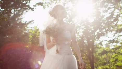 Feliz-joven-novia-está-corriendo-en-un-bosque-soleado-en-vestido-de-novia.