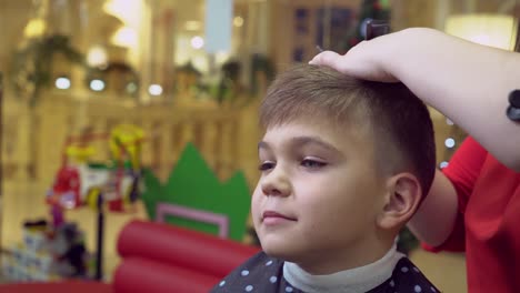 Bebé-de-corte-de-pelo-femenino-en-salón-de-belleza