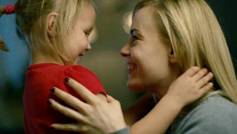 Close-up-Shot-of-a-Beautiful-Mother-Holding-Her-Cute-Blonde-Daughter-and-Smiling.