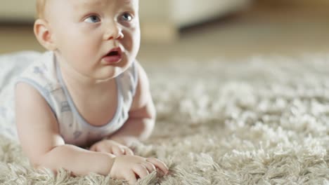 Tiro-de-cerca-de-un-pequeño-bebé-lindo-arrastrándose-en-una-alfombra.