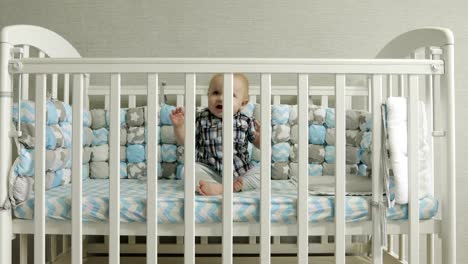 Happy-kid-gets-up-in-the-crib.