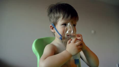 Niño-enfermo-respira-a-través-de-inhalación-nebulizador,-muchacho-con-una-máscara-de-oxígeno-sobre-el-rostro-con-tratamiento-en-casa