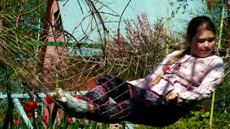 Baby-girl-is-resting-in-the-hammock-near-the-house