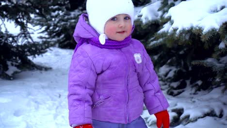 little-girl-standing-on-the-street-in-the-winter-near-Christmas-trees