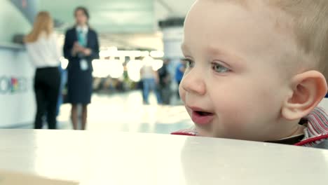 Mutter-gibt-ihr-eine-Tasse-Tee-für-den-Flughafen.-Der-junge-genießt-ein-warmes-Getränk-in-einem-café