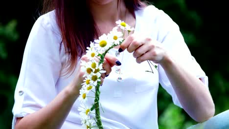 Summer,-Portrait.-In-the-middle-of-a-chamomile-lawn,-in-a-forest,-a-young-woman,-a-brunette-wove-a-wreath-of-chamomiles