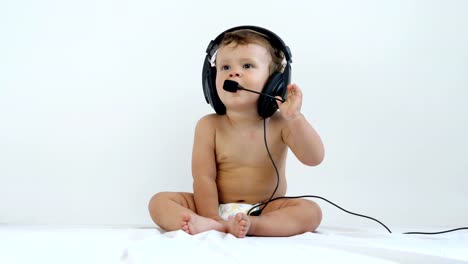 Niño-de-un-año-de-edad-se-sienta-y-escucha-música-en-auriculares.