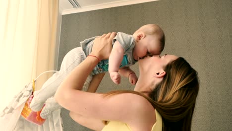 Beautiful-mother-takes-her-baby-in-her-arms-from-a-crib