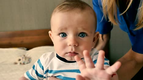 Adorable-blue-eyed-baby-is-looking-in-camera-with-surprise