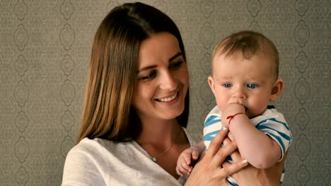 Portrait-of-happy-mother-with-little-son-on-arms