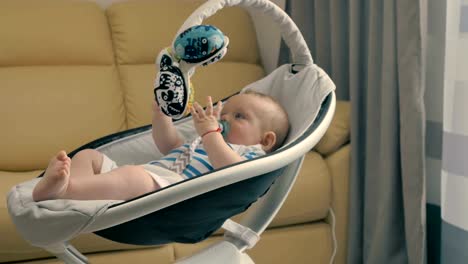 Cute-little-baby-with-dummy-is-rocking-by-the-modern-cradle